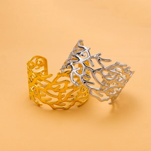 Close-up of gold and silver stainless steel cuff bracelets with coral hollow patterns