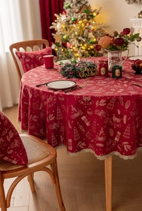 Detail of red Christmas tablecloth featuring golden festive patterns and decorative lace