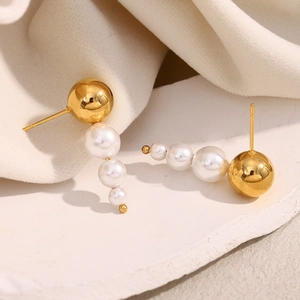 Macro detail of elegant 18K gold plated earrings with triple white pearls on stone