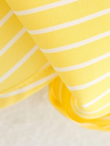 Detailed macro view of yellow and white striped fabric texture on a casual shirt