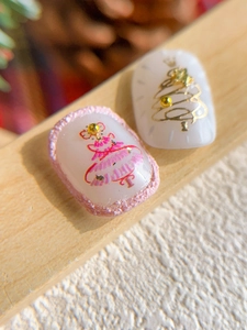 Detail of Christmas nail stickers with gold embossed tree design and pearl accents