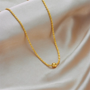 Elegant gold titanium steel necklace with bead pendant on soft silk background
