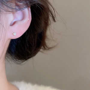 Gros plan de boucles d'oreilles minimalistes en or avec zircon rond et étincelant