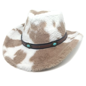 Detail of cow print cowboy hat featuring decorative leather band and turquoise studs