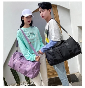 Black and purple large capacity travel duffel bags shown in use with shoulder straps