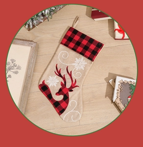 Close-up of burlap Christmas stocking with reindeer reindeer and red plaid cuff