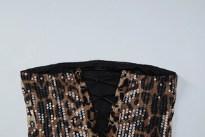 Détail du tissu imprimé léopard avec paillettes argentées et laçage style corset noir