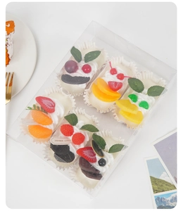 Detail of six realistic artificial fruit cupcakes in a transparent gift box packaging