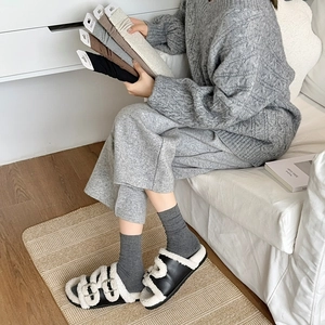 Vertical rib knit crew socks set in earth tones held by a model for a cozy winter look