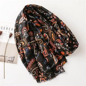 Ethnic paisley pattern black shawl with fringe detail on a minimalist background