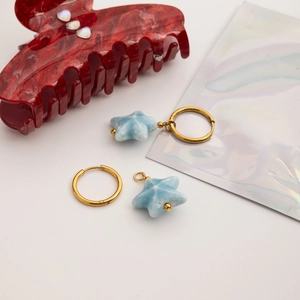 Detailed shot of 18K gold stainless steel hoop earrings with blue starfish ceramic pendants