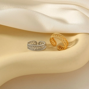 Detail view of woven gold and silver twisted titanium steel rings on white silk