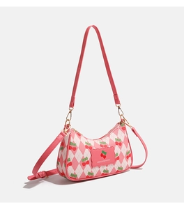 Détail du sac à bandoulière rose à motif cerise avec finitions dorées et matelassage