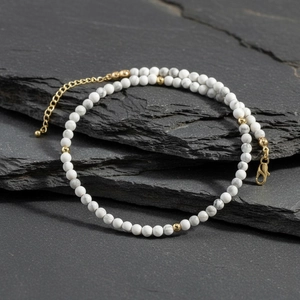 Close-up of white howlite beads and gold accents necklace with lobster clasp