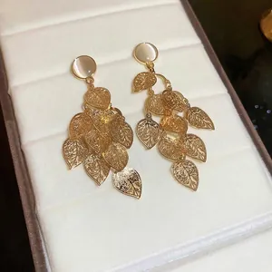 Elegant gold-tone tassel earrings featuring opal-like stones and hollow leaf pendants