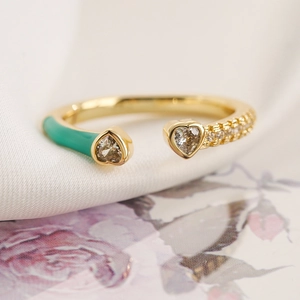 Dettaglio macro dell'anello a cuore placcato oro con smalto verde e zirconi scintillanti