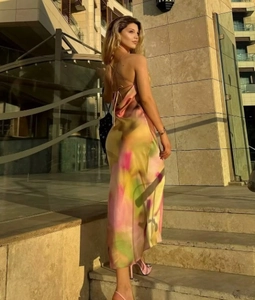 Detail of satin slip dress showing backless tie design and yellow green tie-dye print
