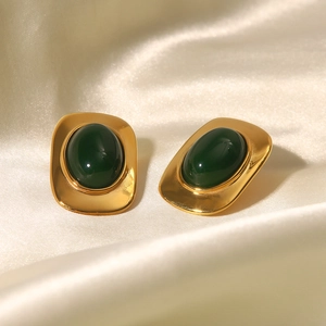 Boucles d'oreilles ovales plaquées or 18 carats avec pierre verte sur fond de soie
