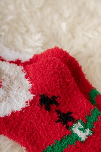 Detailaufnahme der weichen rot-weißen Korallenvlies-Struktur für weihnachtliche Socken
