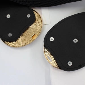 Elastic wide belt for women featuring a gold sunburst buckle on black textured strap
