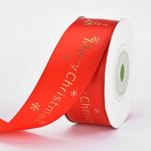 Close-up of red Christmas ribbon with gold Merry Christmas lettering and snowflakes