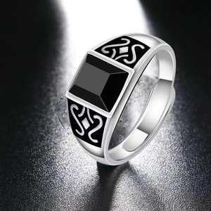 Macro shot of men's vintage silver ring with square black stone and carved side details