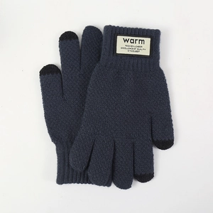Dettaglio di guanti in maglia blu navy con punte touch screen e etichetta tessuta calda
