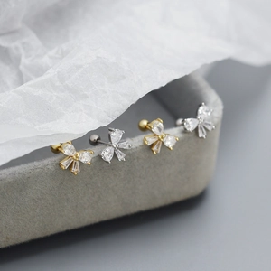 Macro detail of S925 silver bow stud earrings with sparkling zircon on a jewelry box