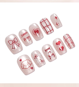 Detail of sweet cat eye press-on nails featuring red bows, hearts, and cute puppy patterns