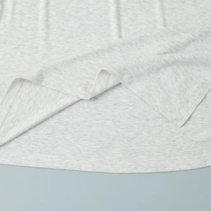 Detail of light gray knit fabric with curved hem and double-needle stitching quality