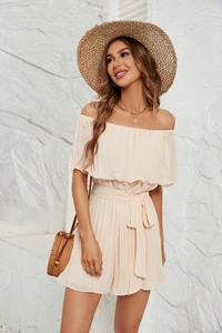 Close-up of pleated off-the-shoulder romper in beige with elegant elastic waist bow