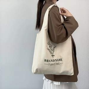Detail of minimalist floral illustration on a cream canvas tote bag with wide strap