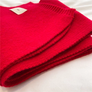 Close-up of red knitted scarf texture showing soft wool fabric on white background