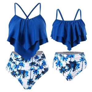 Detail of blue ruffled tankini top and high-waisted tropical palm tree print swimsuit