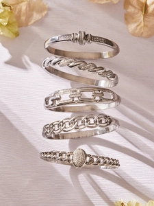 Macro shot of five silver stainless steel bracelets with zirconia inlays on white background