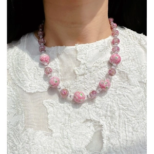 Handmade pink glass bead necklace with floral patterns for a vintage elegant look