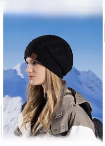 Detail showing cable knit texture and leather sports logo on a black winter hat