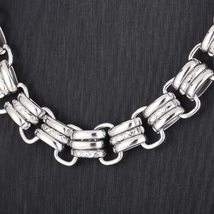 Macro shot of 15mm silver stainless steel chain with engraved wavy texture and metal luster