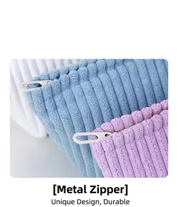 Close-up of corduroy makeup bags with metal zippers in white, blue, and purple tones