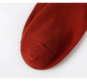 Detailed macro view showing precision stitching and knit texture of dark red cotton socks