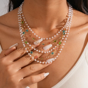 Baroque multi-layer necklace with faux pearls and colorful gemstones on a gold metal chain