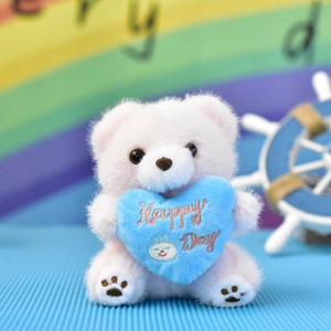 Detailed view of cute plush bear pendant holding a blue heart with Happy Day text