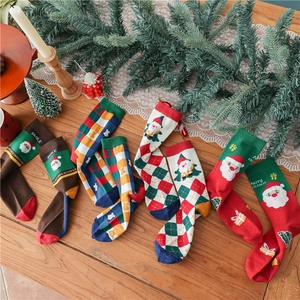 Set of 3 Christmas socks with Santa Claus and festive patterns on a warm wooden table