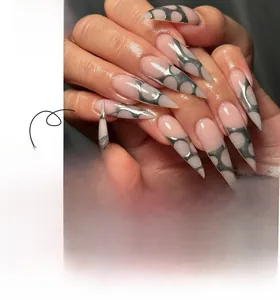 Detail view of long stiletto press-on nails with silver mesh pattern on nude base