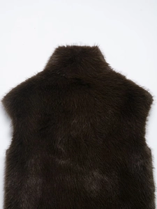 Dettaglio del gilet in ecopelliccia marrone scuro con texture morbida e cuciture