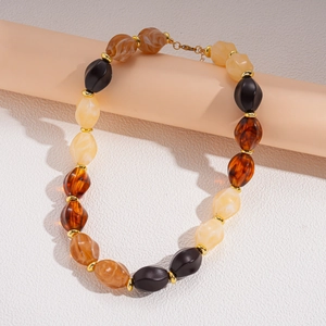 Detail view of ethnic acrylic beaded sweater necklace with gold spacers on stand