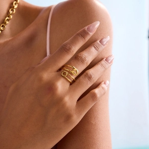 Detail of a luxury gold snake-shaped titanium ring worn on a model's finger