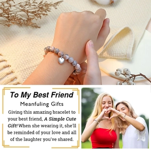 Detail view of stone bead bracelet with heart charm and sentimental gift card for friends