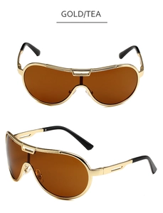 Detail of oversized shield sunglasses with gold metal frame and tinted tea lenses