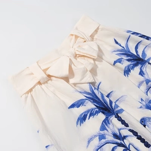Close-up of tropical blue palm print on beige skirt with elastic bow-tie waist detail